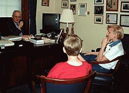 Congressman Pascrell sitting behind his office desk talking with Melody Stepneski and her son Bryan seated with their backs to the camera.