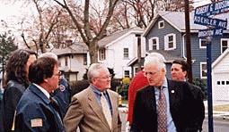 Congressman Pascrell with Mayor Ray McCarthy and John Frisco together infront of a three houses, one blue and two white, by a street sign reading Koehler Avenue and Brighton Avenue