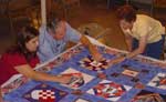 Tom is putting ties in a quilt that will be given to the 6 yr old duaghter of a 9-11 fallen firefighter