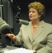 Photo: Senator Stabenow in a radio studio speaking into a microphone.