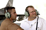 F-16 crew chief Staff Sgt. Andy Adducchio briefs Drew Carey 