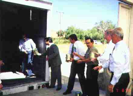 Congressman Cesar Baylon of Tecate, Mexico (at left in truck) receives a can of food from Congressman Juan Hernandez of Mexicali, as Congressman Duncan Hunter is ready with another delivery.  To the right of Hunter are Lions Club member Francisco Flores, World Emergency Relief President Reverend Joel MacCollam and Allen Brown of the El Cajon Rotary.