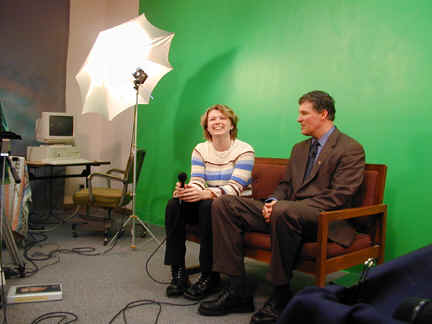 Student and Inslee sit in front og green screen