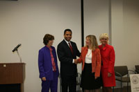 Congressman Jackson shaking hands with Lori Levin (Executive Director of the Illinois Criminal Justice Information Authority) while Ida Anger (Program Manager for Metropolitan Family Services) and Marilyn Mazewski (also of the Justice Authority) look on