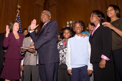 House Majority Whip James E. Clyburn being sworn in to the 110th Congress on January 4, 2007, by the first woman Speaker of the House, Nancy Pelosi, as his family looks on.