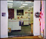Photograph of Jeff's office in Washington D.C. located in the Hart Building room SH 703. it shows the front entrance and two interior reception desks. The New Mexico and United States flags are outside the doorway.