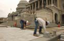 Stone masons lay granite paving stones near the Senate Steps