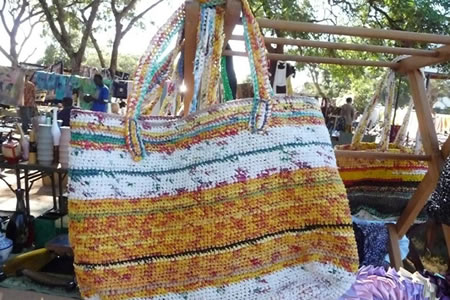 Widows and single moms of Chikumbuso, Zambia crotchet strips of plastic grocery base into indestructible reusable bags to support a school for their children and community orphans.