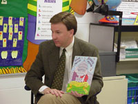 Congressman Rogers reads a book to a classroom.