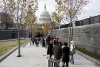 people standing outside of U.S. Capitol on tree-lined path waiting to enter through new Capitol Visitor Center doors on the East side of the U.S. Capitol