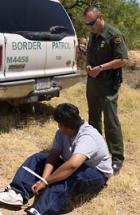 Border Patrol agent places a Mexican National under arrest for transporting drugs into the U.S.