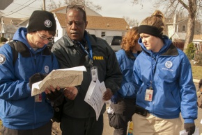 Members of FEMA Corps and a FEMA Community Relations specialist review a street map while doing reaching out to residents in Union Beach, N.J.