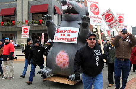 Sheet-metal workers from Toledo, Ohio, escort an inflatable rat during a march to the state Capitol grounds in Lansing, Mich., on Tuesday, Dec. 11, 2012. The crowd is demonstrating against legislation that would make Michigan the 24th state with a right-to-work law. (AP Photo/Carlos Osorio)