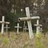 White metal crosses mark graves at the cemetery of the former Arthur G. Dozier School for Boys in Marianna, Florida