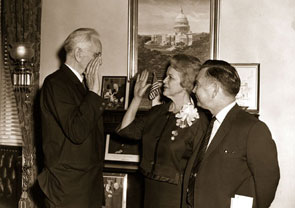 <a href="/member-profiles/profile.html?intID=7">Irene Baker</a> of Tennessee, widow of Howard Baker, Sr., poses for a ceremonial picture of her swearing-in as a U.S. Representative on March 10, 1964. Speaker John McCormack of Massachusetts (left) administers the oath. Looking on is Majority Leader Carl Albert of Oklahoma.