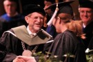 Photo of President John Dunn congratulating graduate at commencement.