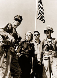 Accompanied by U.S. Marine officers, Senator <a href="/member-profiles/profile.html?intID=230">Margaret Chase Smith</a> tours a U.S. military facility. Smith was the first woman to serve on the Armed Services Committee in both the House and the Senate