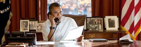 Obama sitting at a desk on the phone