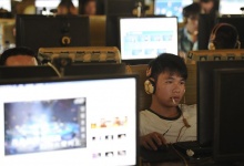 A man smokes as he uses a computer at an internet cafe in Hefei, Anhui province, September 15, 2011. REUTERS/Stringer 