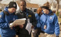 Members of FEMA Corps and a FEMA Community Relations (CR) specialist review a street map while doing reaching out to residents in Union Beach, N.J.
