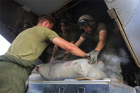 Photo of U.S. Marines loading bags of concrete.