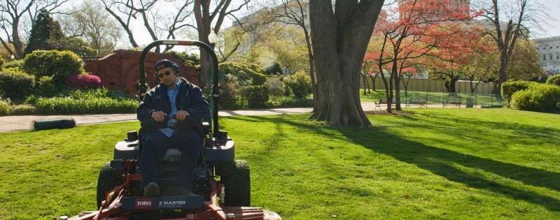 An AOC worker mowing the grass on the grounds of the U.S. Capitol