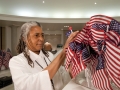 AOC employee assembling a bunch of tiny American flags for a display