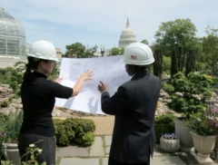 AOC Architects holding a blueprint while working 