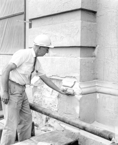 Owen Ramsburg, in 1960, surveys stone damage at the Capitol. Photo from AOC archives.