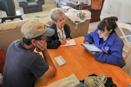 Samantha Miller (right), a FEMA Corps member from New York State, uses her tablet computer to help a resident affected by the April 17 fertilizer plant explosion register for Federal Emergency Management Agency assistance