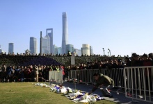 People lay down flowers during a memorial ceremony in memory of people who were killed in a stampede incident during a New Year's celebration on the Bund, in Shanghai January 1, 2015. REUTERS/Aly Song