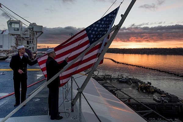 Seaman Aaron Thompson, from Columbia, S.C., and Seaman Jake Ridley, from Oklahoma City, raise the ensign during morning colors aboard the aircraft carrier USS John C. Stennis (CVN 74). John C. Stennis is conducting a scheduled maintenance availability at Naval Base Kitsap-Bremerton.  U.S. Navy photo by Petty Officer 3rd Class Dakota Rayburn (Released)  161103-N-BR551-049