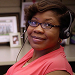 Woman at desk wearing telephone headsets