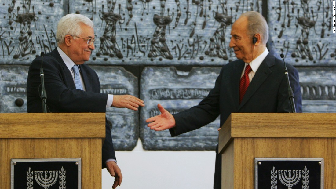 Palestinian President Mahmoud Abbas reaches to shake hands with Israeli President Shimon Peres prior to their meeting in Jerusalem on July 22, 2008. Abbas had threatened to withdraw his forces from West Bank cities unless Israel&#39;s military halted its raids into the areas.
