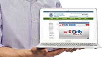 Case Tracker thumbnail: A man holding laptop displaying myE-Verify homepage