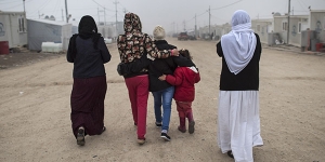 “M.”, center, a Yazidi teen who escaped sex slavery under the Islamic State group, is comforted by relatives before leaving to be resettled in Germany, at a camp near Dohuk, Iraq, Jan. 24, 2016. Islamic State leaders have made sexual slavery integral to the group’s operations, aggressively pushing birth control on the victims to keep the trade running. (Lynsey Addario/The New York Times)