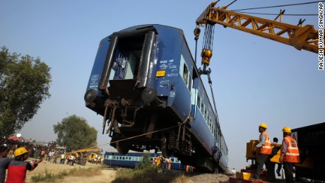 Rescuers lift one of the 14 coaches of an overnight passenger train that rolled off the track near Pukhrayan village Kanpur Dehat district, Uttar Pradesh state, India, Sunday, Nov. 20, 2016. 
