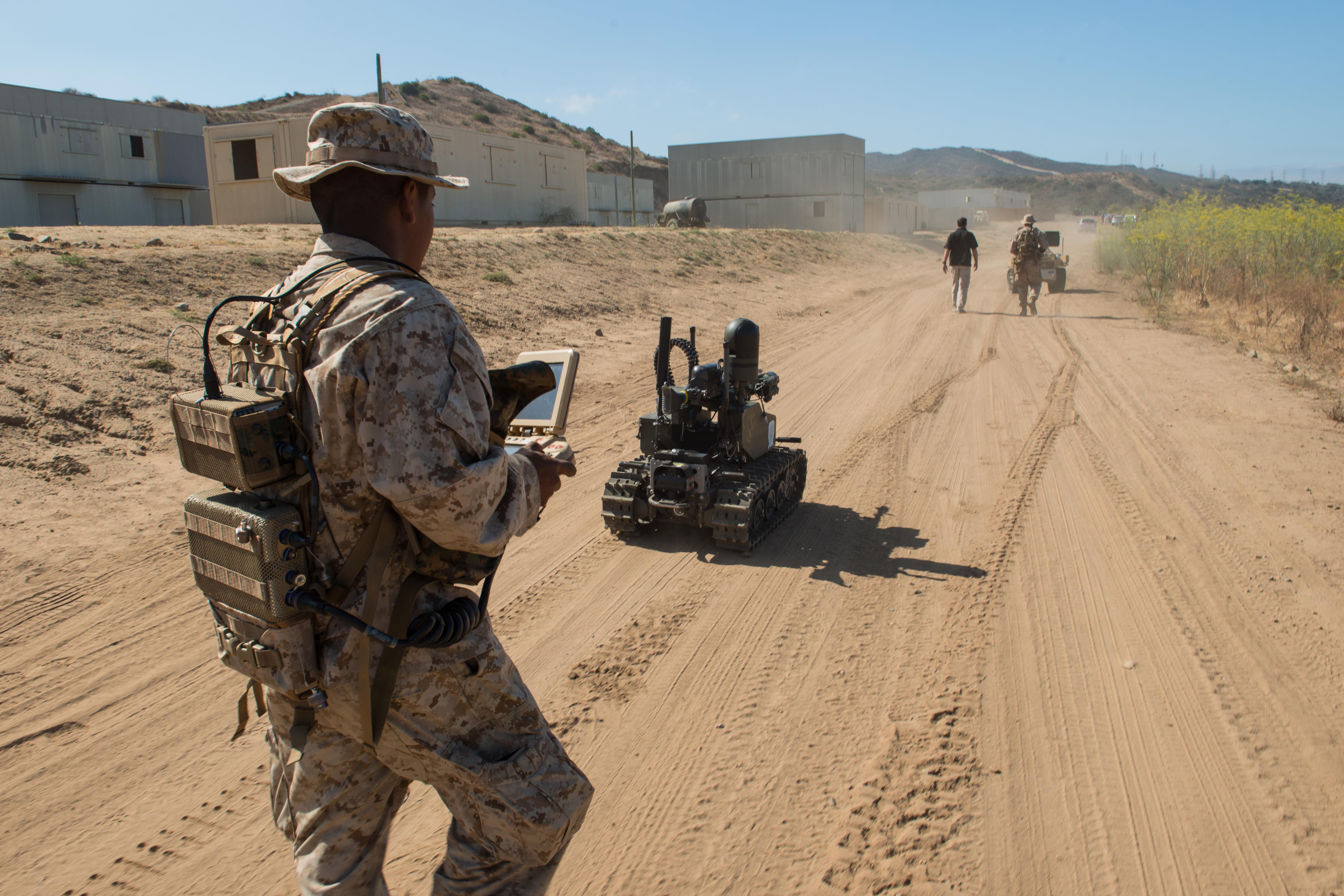 Marine Corps Pfc. Edgar Langle operates a newly developed Modular Advanced Armed Robotic System in a field environment 