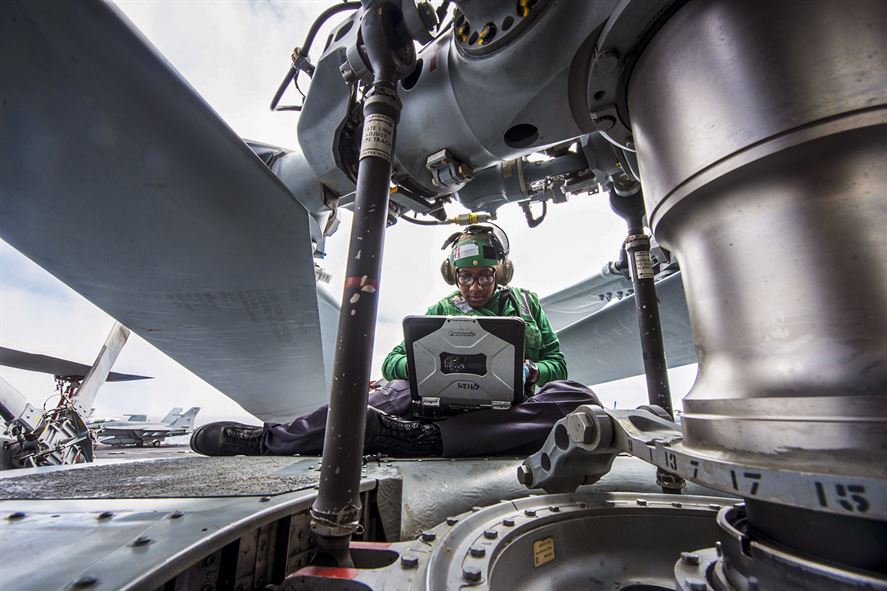 Navy Seaman Janeih Bain performs maintenance on the rotor hub of an MH-60R Seahawk helicopter.