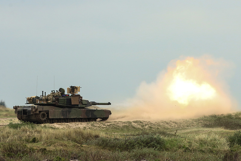 An M1A2 Abrams Main Battle Tank firing at targets.