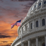 Capitol Dome and U.S. Flag against dramatic sky