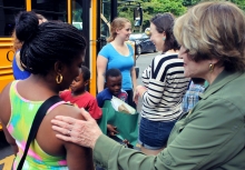 Congresswoman Slaughter Stands with Young Mother in Front of a School Bus