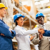 warehouse manager shaking hands with warehouse worker