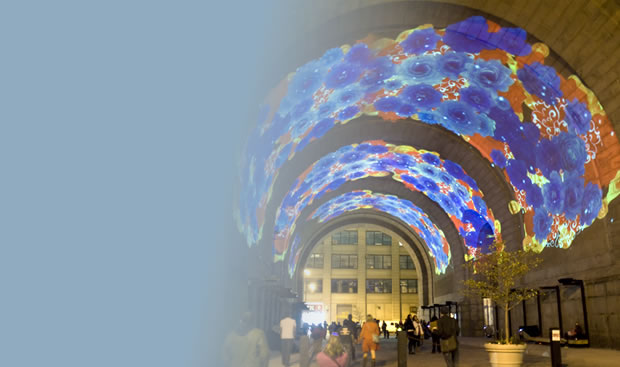 The dome of a large building is illuminated with colorful designs.