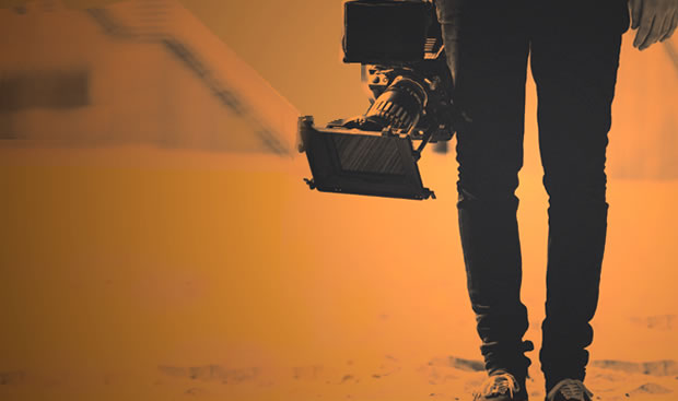 Partial image of a man carrying a film camera.