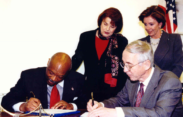 Nancy Pelosi and Senator Feinstein watch as Navy Secretary England and Mayor Brown sign an agreement for the cleanup and transfer of Hunters Point to San Francisco in January 2002