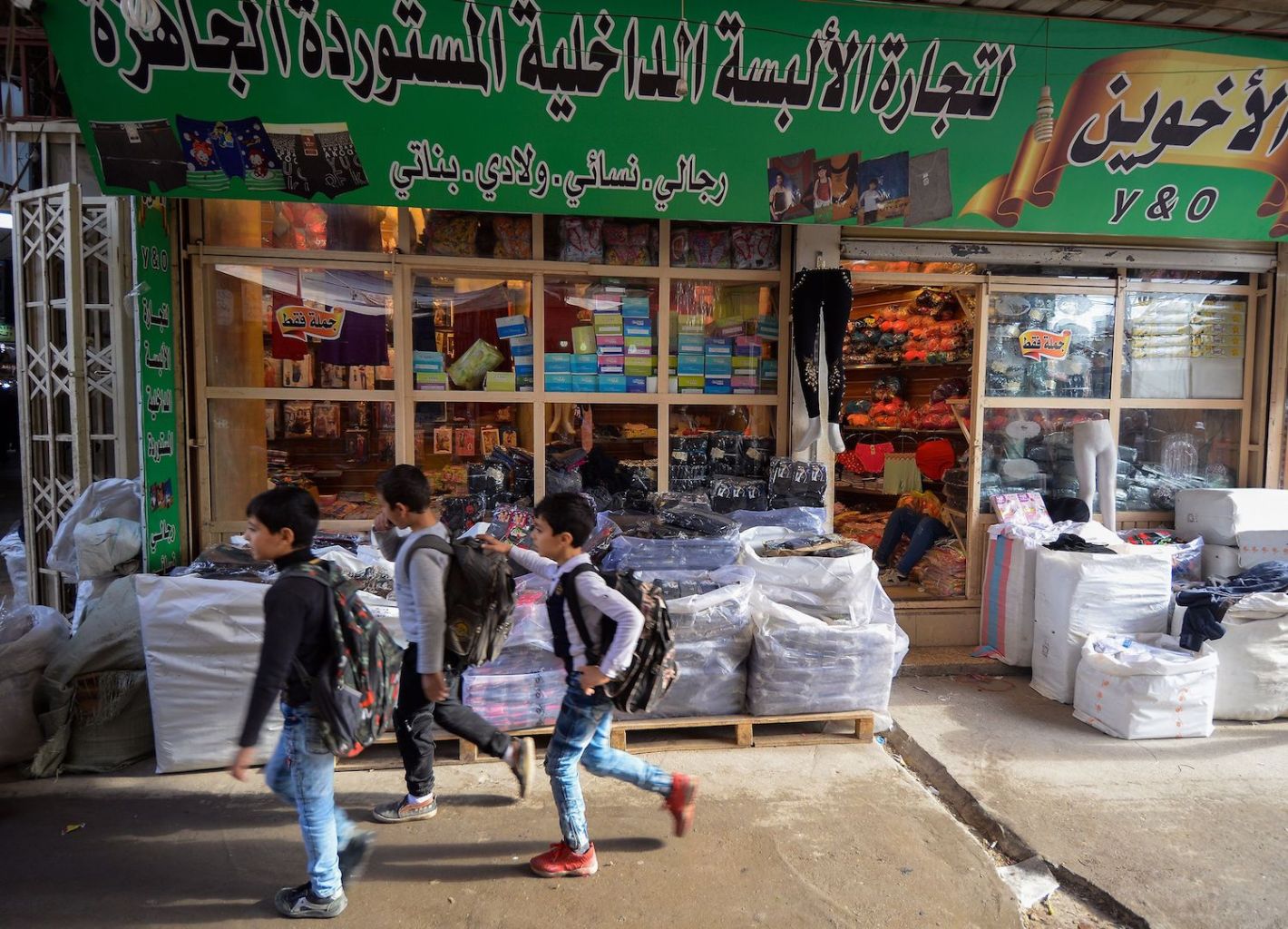 Iraqi boys walk past a shop in a local market in the northern city of Mosul on Nov. 21. ( Zaid al-Obeidi/AFP/Getty Images)
