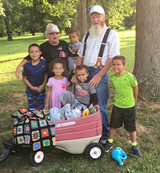 An Elderly Caucasian man and woman with their four foster boys, and one foster girl.