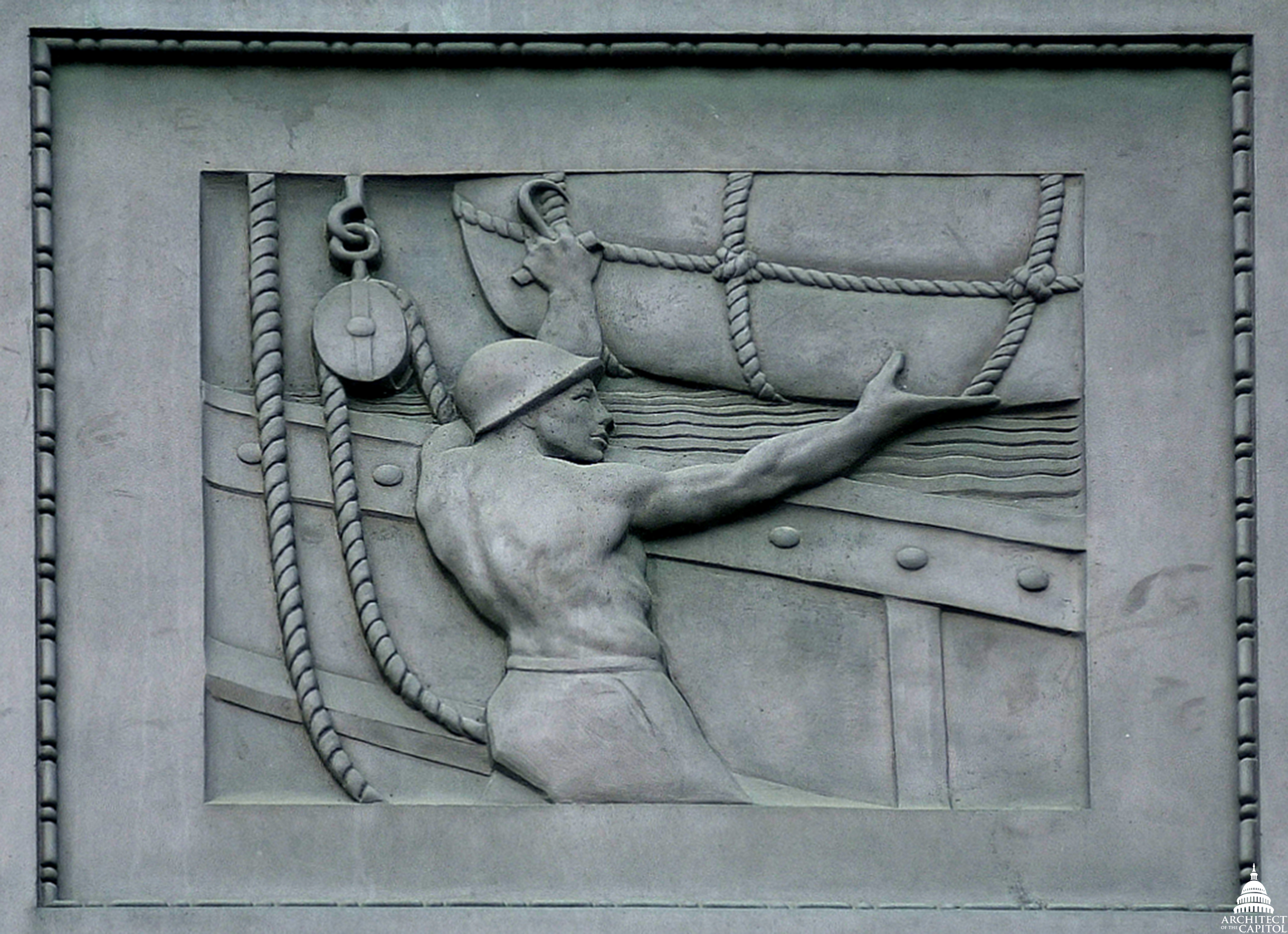 A sailor maneuvers cargo in a panel on exterior of the Dirksen Senate Office Building. 