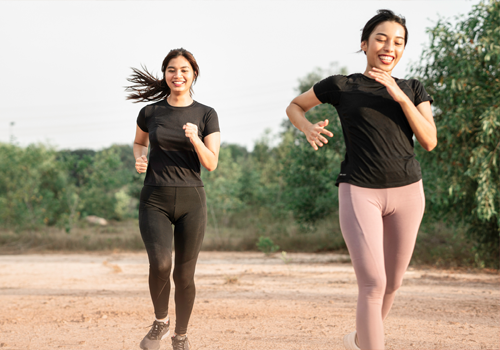 Two women jogging on a trail